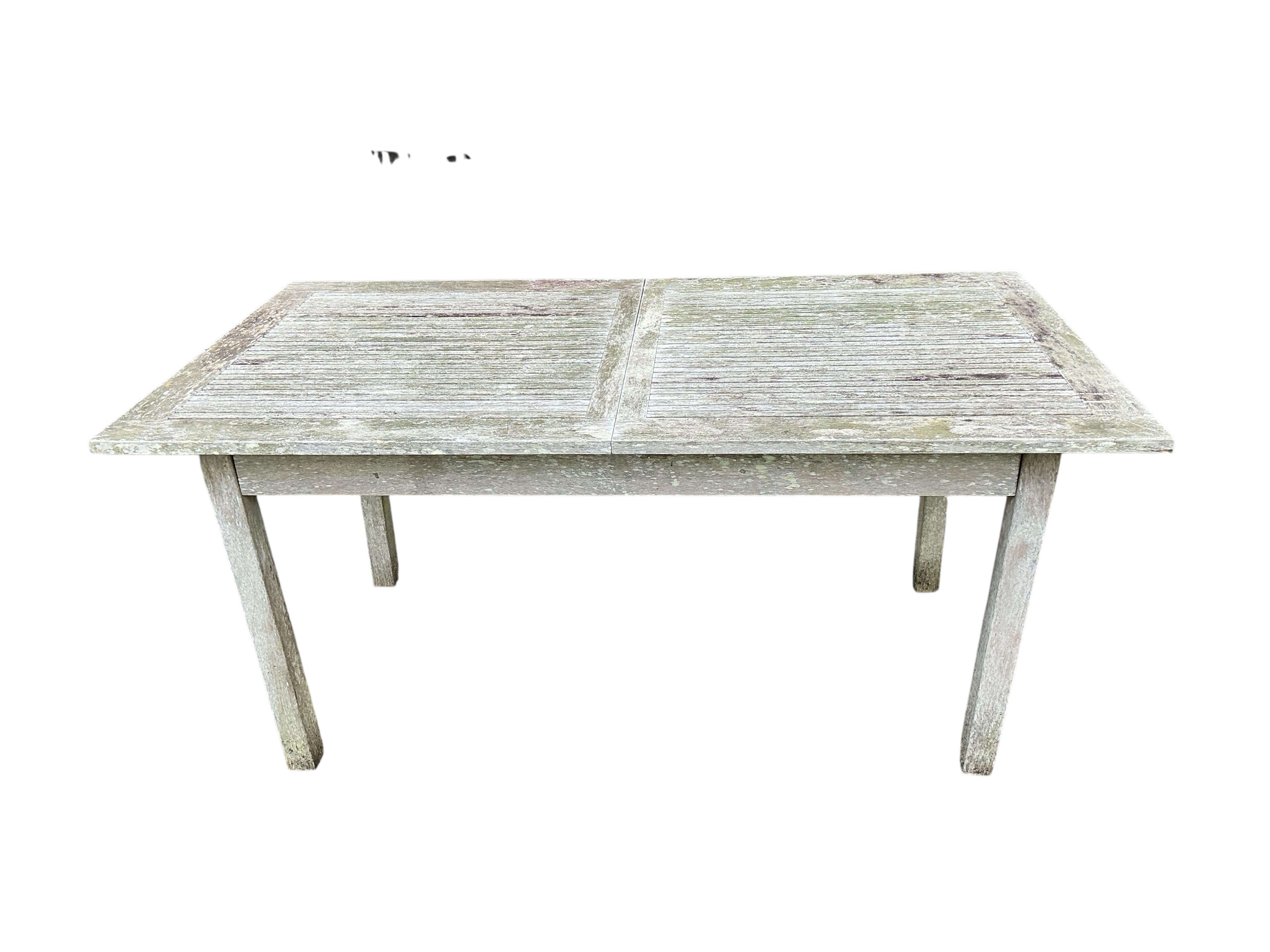 An Indian Ocean Trading Company rectangular teak extending garden table, width 164cm, depth 90cm, height 74cm, four folding chairs and a canvas parasol with metal stand